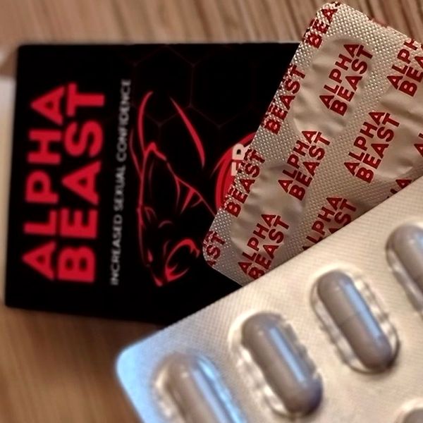 Boîte noire et rouge Alpha Beast avec une plaquette de gélules grises